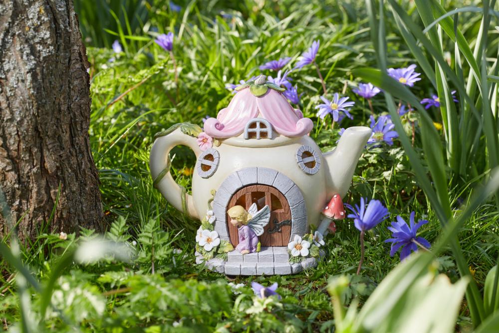 Feenhaus in Form einer Teekanne im Garten stehend, unbeleuchtet.